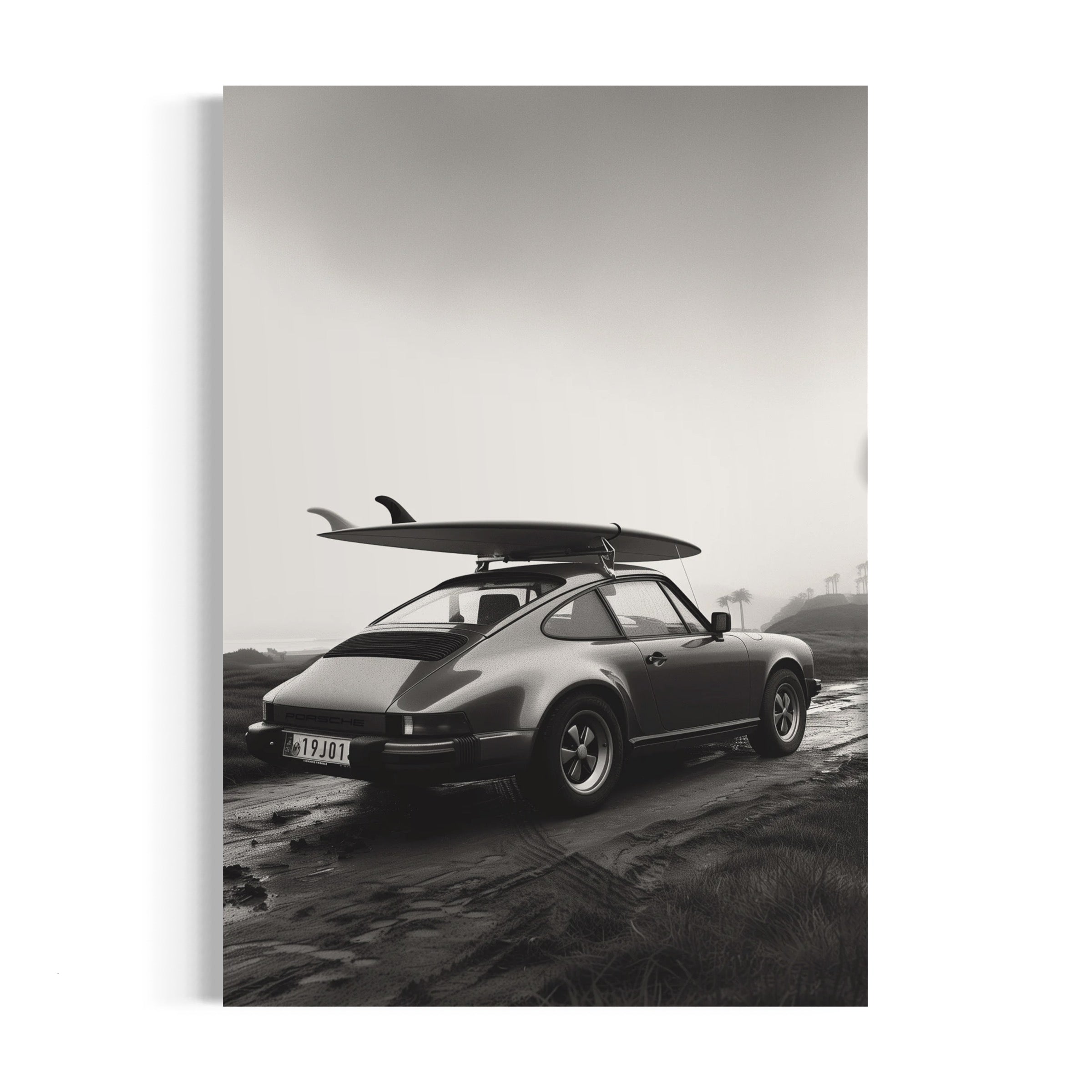 a black and white photo of a car with a surfboard on top of it