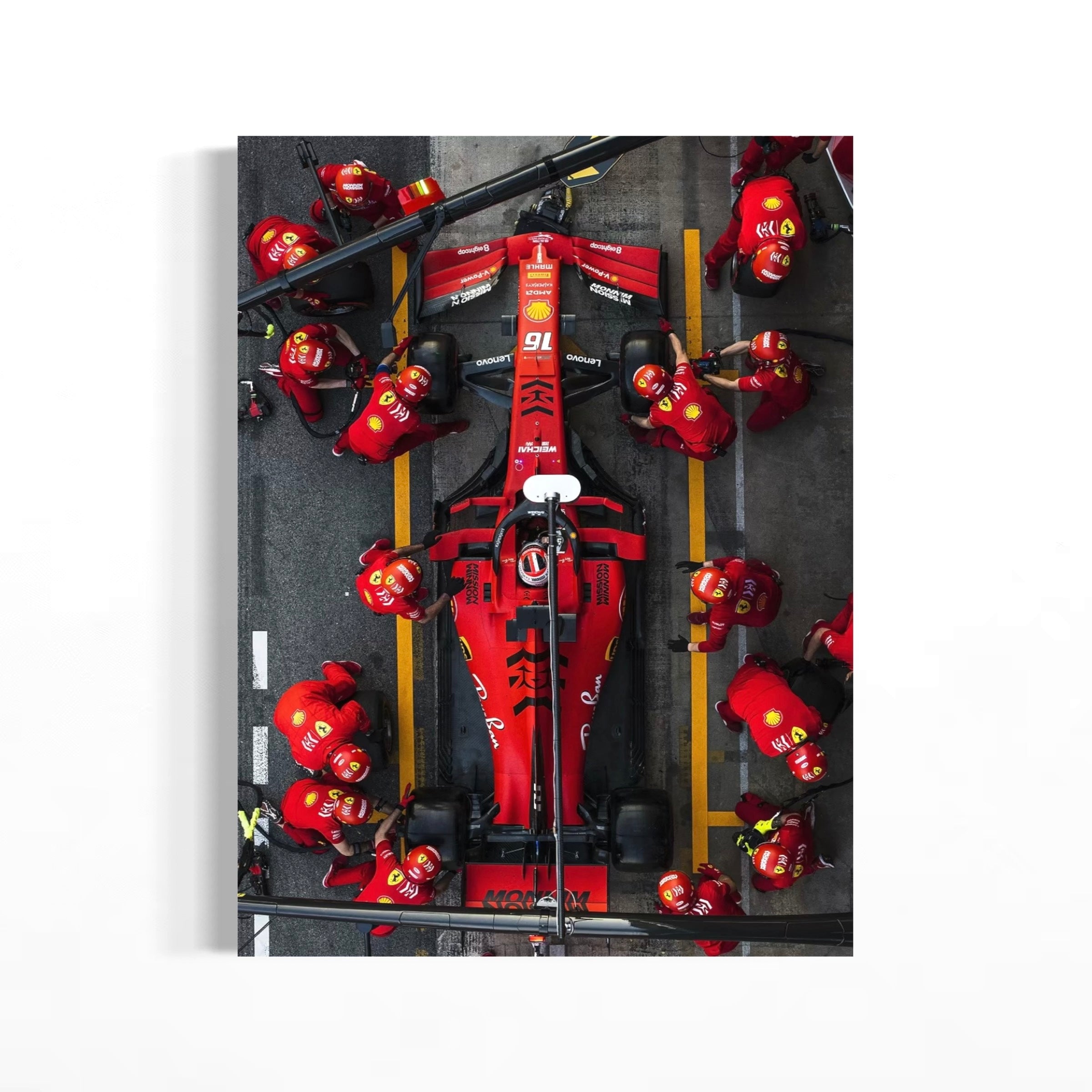 A group of people in red uniforms working on a red Formula 1 race car, with the car prominently displayed in the center of the image.