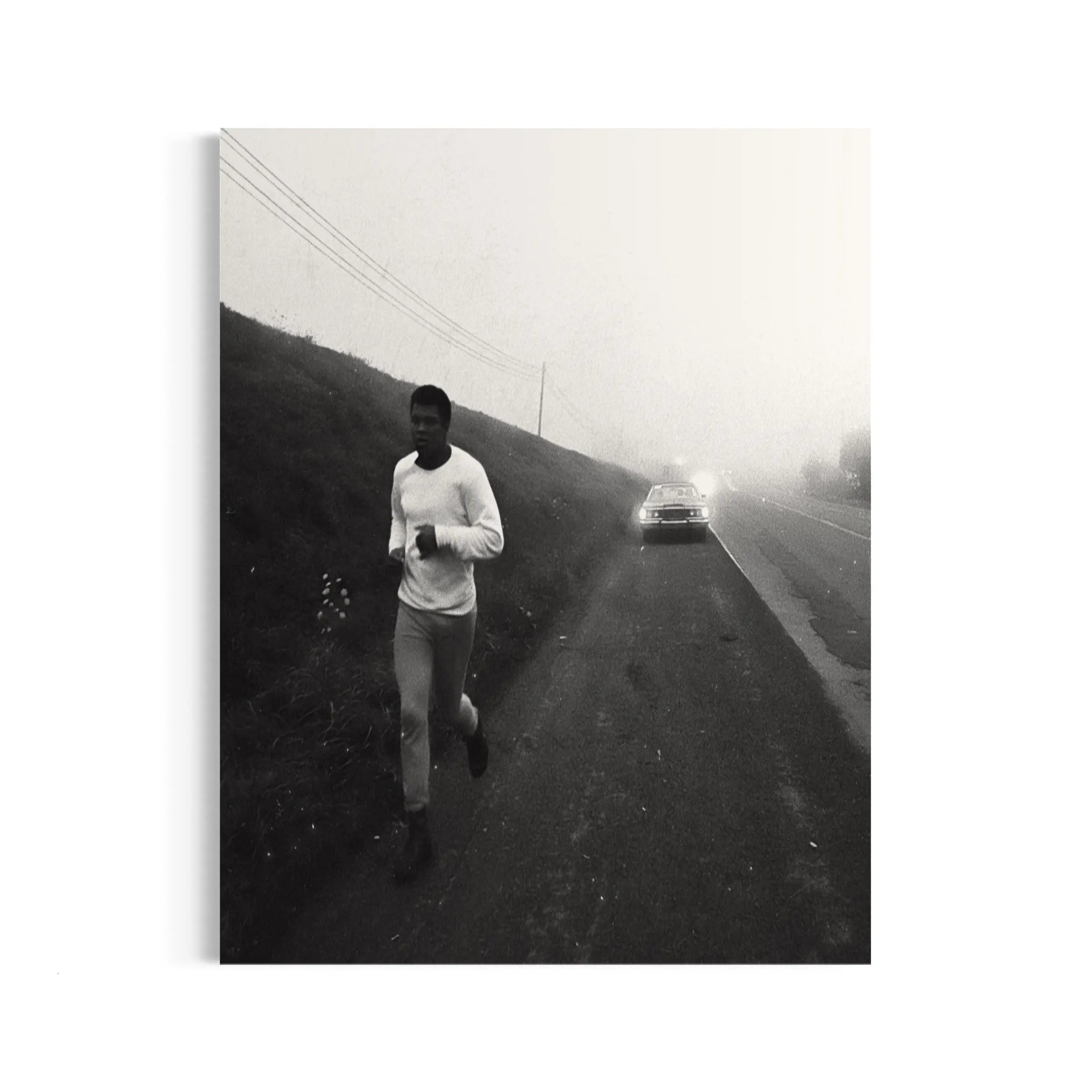 a man running down a road next to a car