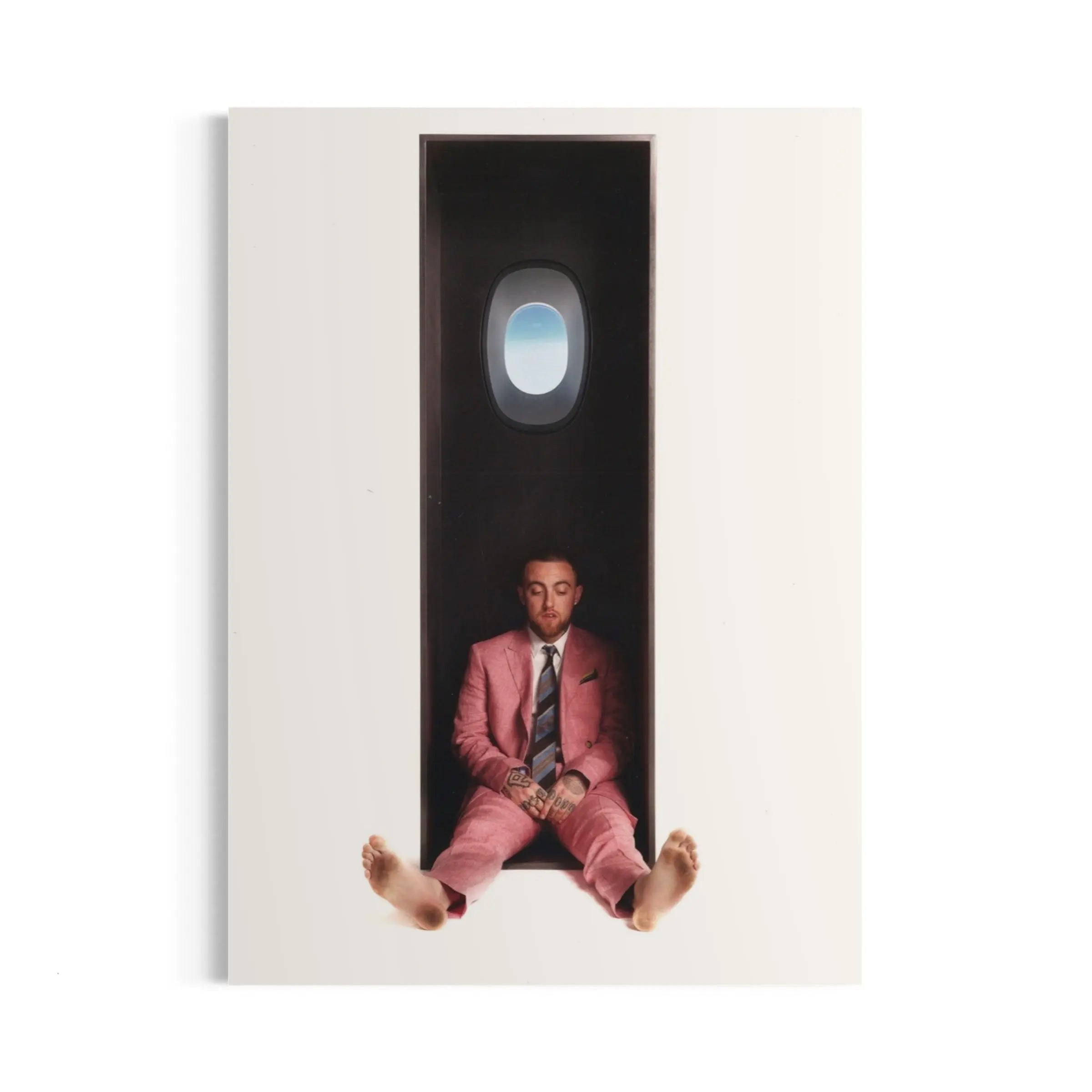 a man in a pink suit sitting in a doorway