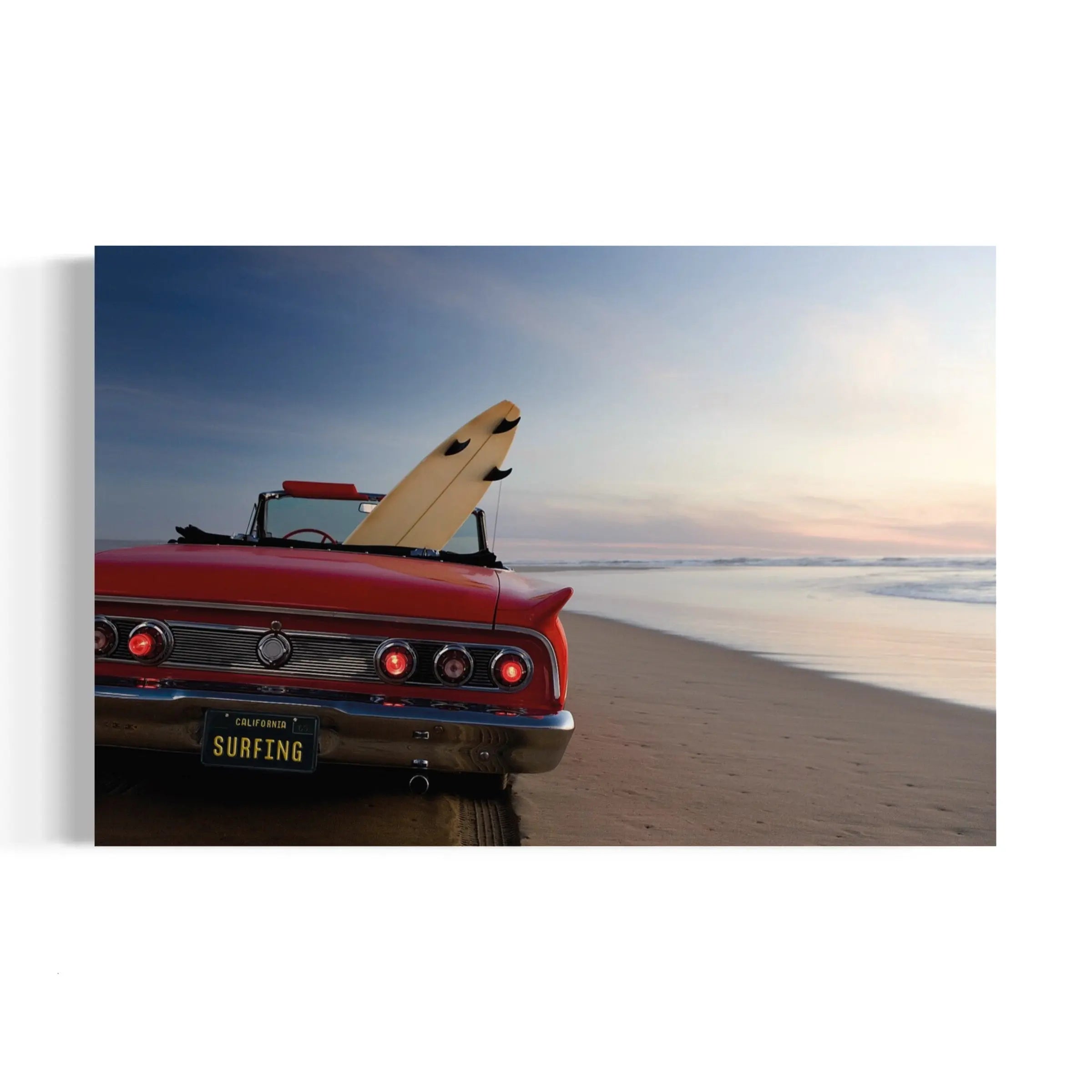 a red car parked on top of a sandy beach