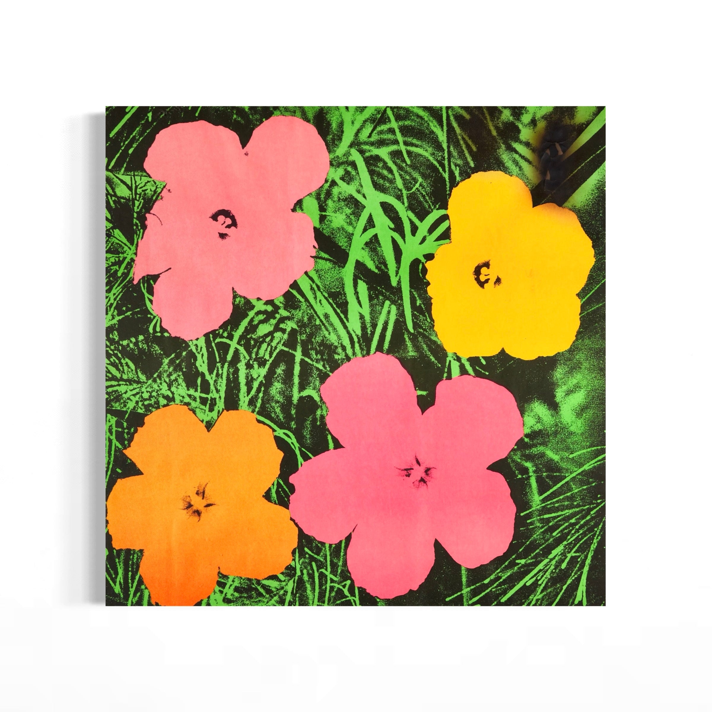 The image is a vibrant collage of four colorful flowers, each with a unique shape and color, set against a lush green background.
