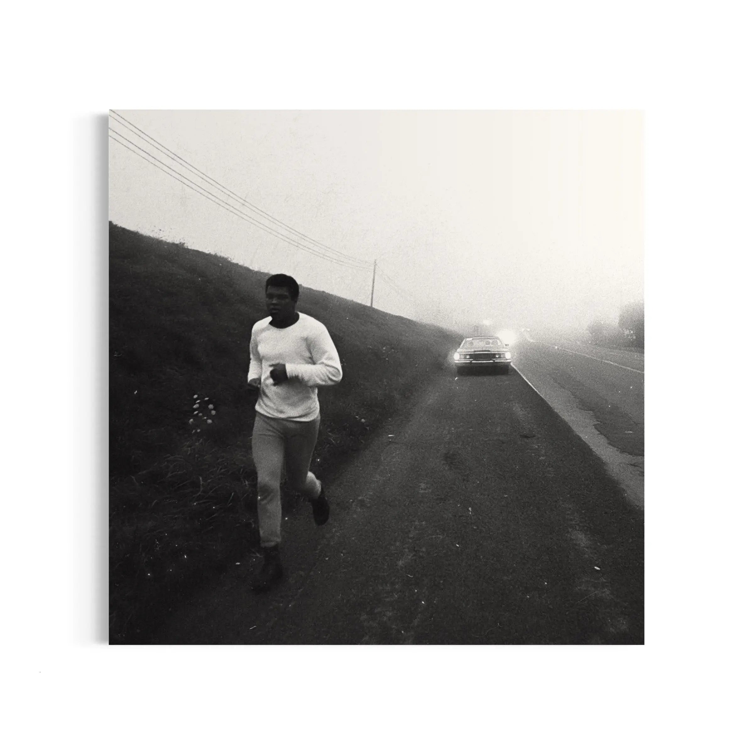 a man running down a road next to a car