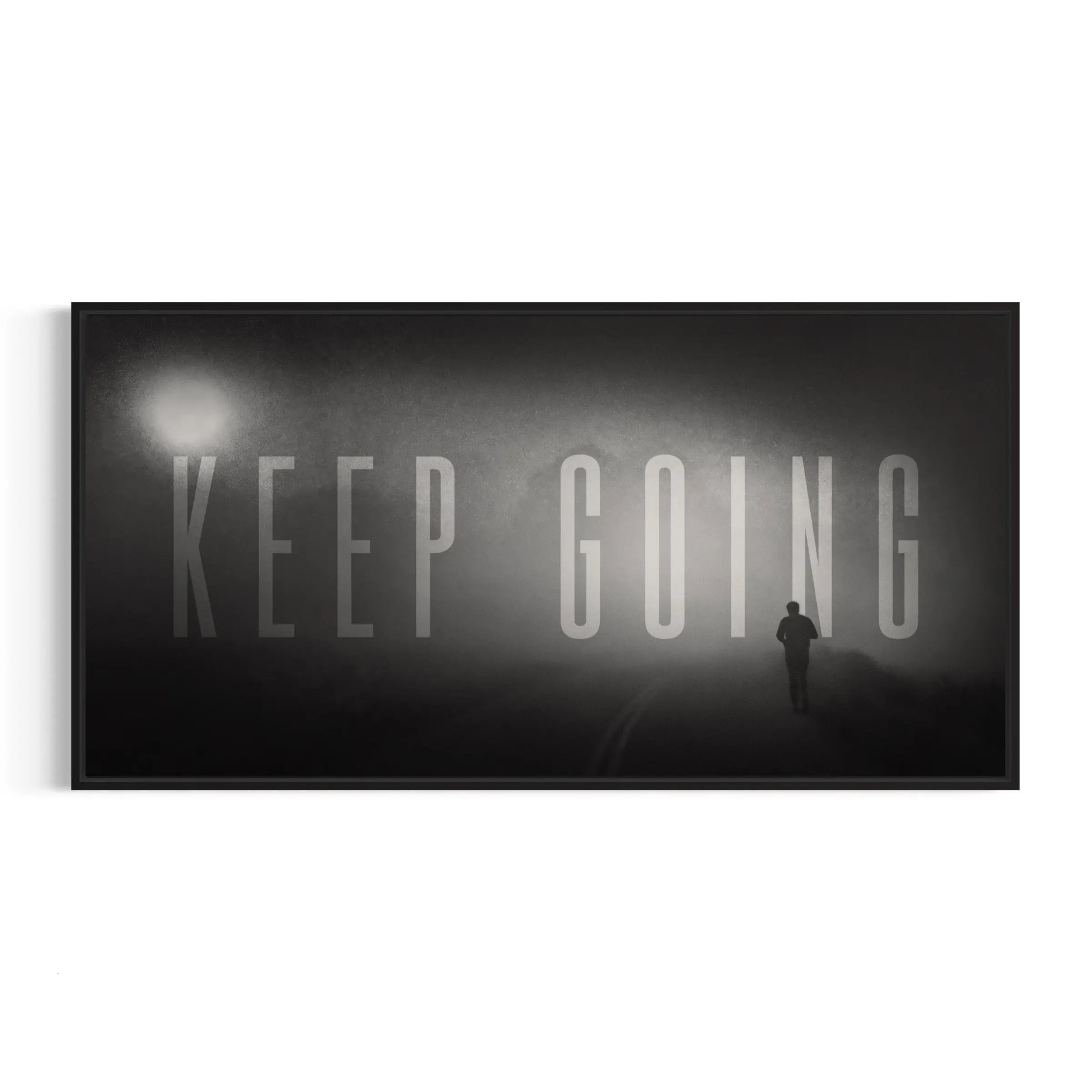 a black and white photo of a man standing in front of a keep going sign